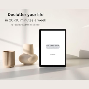 May include: A digital tablet displaying a white screen with the text Life Admin Reset, Your simple system to feel caught up again. Above the tablet, text reads Declutter your life in 20-30 minutes a week, 15 Page Life Admin Reset PDF.