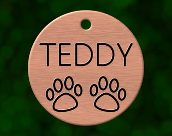 Custom paw prints dog tag. Round pet ID name tag personalized with deep engraving. Handmade pet product. Unique pet gift.