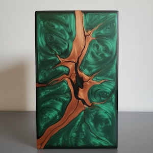 Peut inclure: Pièce d'art rectangulaire en bois avec un design vert et marron saisissant. L'œuvre présente une résine époxy verte tourbillonnante avec un motif de grain de bois naturel marron, créant une esthétique unique. La pièce a une bordure noire. Dimensions en centimètres.