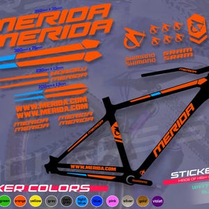 Op de afbeelding: Een zwart fietsframe met oranje en blauwe details, vergezeld van een sticker set met het merk "MERIDA". De stickers bevatten diverse grafische elementen en afmetingen zoals 350mm x 35mm. De set is gemaakt van hoogwaardige Duitse folie.