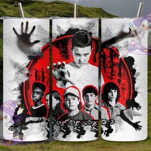 May include: A white tumbler featuring a graphic of characters from a popular science fiction series. The design includes a red circular element and a dark hand reaching out. The tumbler has a silver straw.