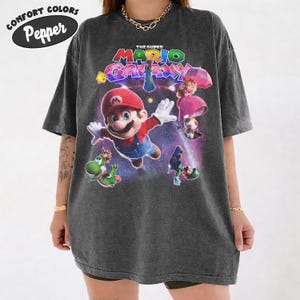 Puede incluir: Una taza de cer&aacute;mica blanca con un asa negra y el texto "But First, Coffee" en negrita negra. La taza se encuentra sobre un fondo neutro, resaltando su dise&ntilde;o sencillo.