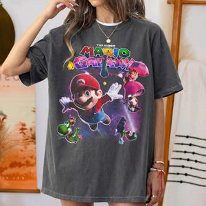 Puede incluir: Una taza de cer&aacute;mica blanca con un asa negra y el texto "But First, Coffee" en negrita negra. La taza est&aacute; sobre una superficie blanca. La taza mide aproximadamente 10 cm de alto.