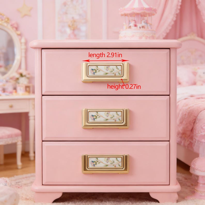 Peut inclure: Une table de chevet rose &agrave; trois tiroirs avec des poign&eacute;es dor&eacute;es. Chaque poign&eacute;e pr&eacute;sente un motif floral. La poign&eacute;e du tiroir sup&eacute;rieur mesure 7,39 cm de long et 0,69 cm de haut. La table de chevet est dans une pi&egrave;ce &agrave; th&egrave;me rose.