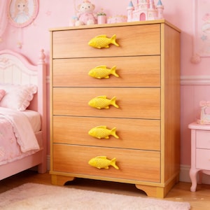 以下が含まれることがあります： 明るい茶色の木製ドレッサー。5つの引き出しがあり、それぞれに鮮やかな黄色の魚の形をした取っ手がついています。ドレッサーはピンク色の部屋にあり、子供部屋を連想させます。全体的に、気まぐれで遊び心のあるデザインです。