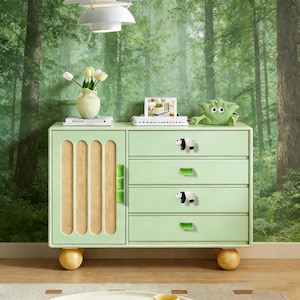 以下が含まれることがあります： 4つの引き出しとキャビネットドアを備えた、明るい緑色のドレッサー。キャビネットドアには垂直の木製スラットがあります。引き出しにはパンダ型のノブと緑色の長方形のハンドルが付いています。ドレッサーは丸い明るい色の木製の脚の上にあります。緑色のヨーダのぬいぐるみがおもちゃの上に座っています。