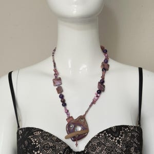 May include: A white ceramic mug with a black handle and the text "But First, Coffee" in a bold, black font. The mug is set against a neutral background, highlighting its simple design. The mug appears to be approximately 4 inches tall.