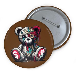 Könnte beinhalten: Ein runder Button mit braunem Hintergrund zeigt ein sitzendes Teddybär-Design. Der Bär ist weiß mit Dollarzeichen auf den Füßen, und sein Kopf ist mit roten und geldbezogenen Details geteilt. Ein zweiter Button ist sichtbar.