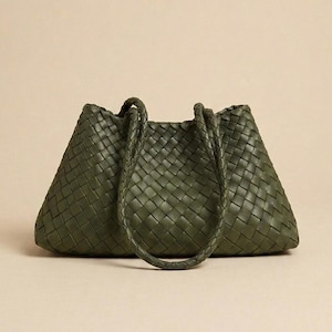 May include: An olive green handbag featuring a woven leather construction with a distinct grid pattern. The bag has a trapezoidal shape with two braided shoulder straps attached to the top, providing a consistent texture across the entire surface.