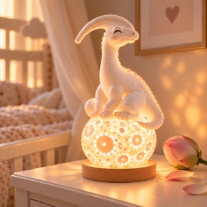 May include: A white dinosaur-shaped lamp sits atop a spherical base featuring a glowing, intricate floral pattern. The lamp is mounted on a circular wooden stand, emitting a warm, soft light that illuminates the dinosaur's smooth, matte surface.