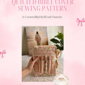 May include: A pink quilted Bible cover sewing pattern with floral accents. The cover has pockets for pens and is held by a hand. The text reads "QUILTED BIBLE COVER SEWING PATTERN" and "A Covered By His Word Pattern".