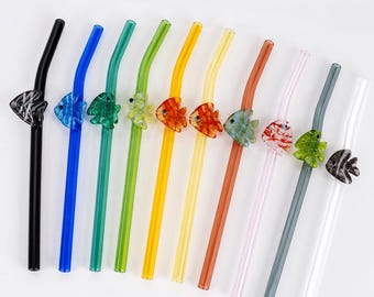 Puede incluir: Una colección de once pajitas de vidrio curvadas, cada una con un pequeño pez decorativo de vidrio unido al lateral. Las pajitas vienen en una variedad de colores translúcidos que incluyen negro, azul, verde, amarillo, naranja, rosa, gris y blanco.