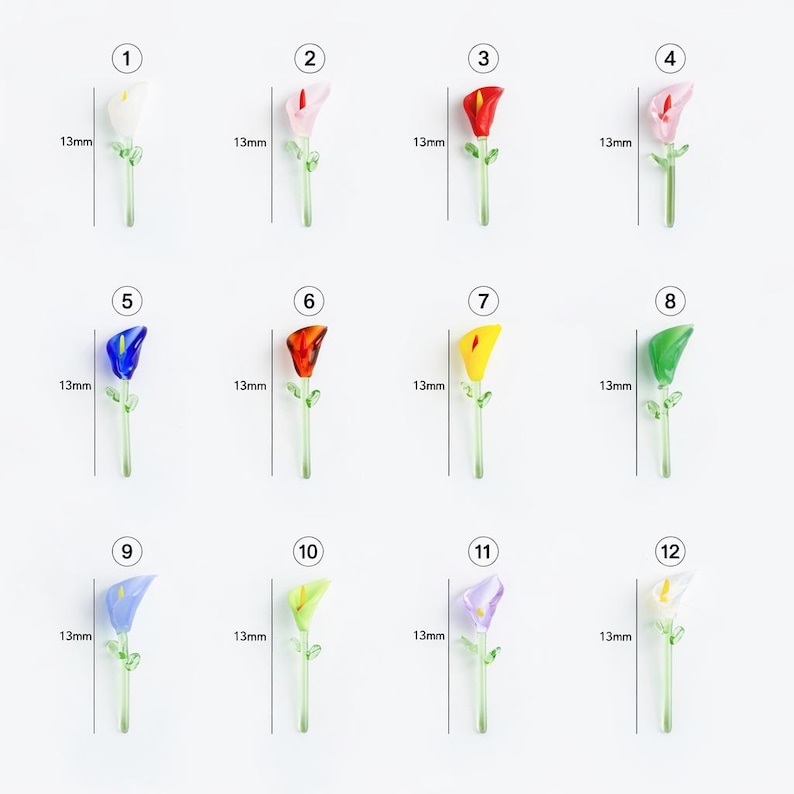 May include: A collection of twelve miniature glass calla lily flowers in various colors, each approximately 0.5 inches tall. The flowers include white, pink, red, blue, orange, yellow, green, and purple, with green stems and leaves.