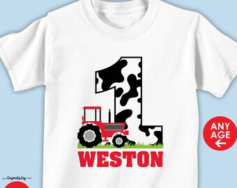 May include: White t-shirt with a red tractor and a black and white cow print number one. The text "Weston" is below the tractor.  Any age is written on the right side of the image.