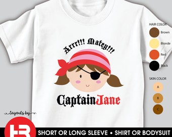 以下が含まれることがあります： 白いTシャツ。海賊の女の子の漫画デザイン。イラストには、赤とピンクのバンダナ、眼帯、茶色の髪が含まれています。「Arrr!!! Matey!!!」と「Captain Jane」というテキスト。半袖または長袖で利用できます。