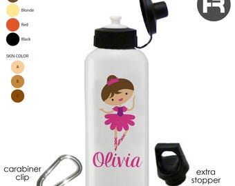 May include: White water bottle with a black lid and a pink ballerina graphic. The bottle includes the name "Olivia" in pink. A silver carabiner clip and an extra stopper are included.