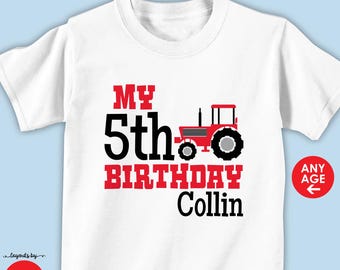 May include: White short-sleeved t-shirt with a red and black tractor graphic. The shirt features the text "MY 5th BIRTHDAY Collin" in red and black. A red circle with the words "ANY AGE" is on the right side.