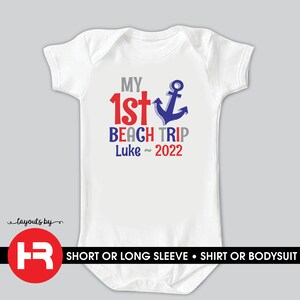 May include: White baby onesie with red, blue, and gray text that reads "My 1st Beach Trip Luke~ 2022". A blue anchor graphic is next to the text.