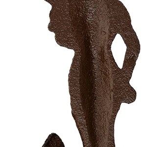 May include: A brown cast iron mermaid wall hook with a hanging loop on the back. The mermaid is in a standing pose with her arm raised in a salute.