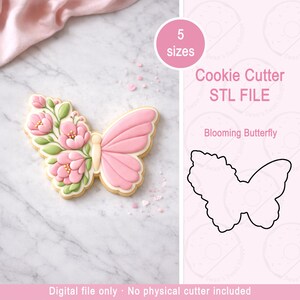 Può includere: Un biscotto a forma di farfalla rosa decorato con fiori rosa e foglie verdi. L'immagine include anche un contorno di taglia biscotti a farfalla e il testo "Cookie Cutter STL FILE" e "Blooming Butterfly".