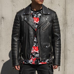 May include: Black leather motorcycle jacket with a classic asymmetrical zip closure, quilted shoulder and arm details, and multiple zippered pockets. The jacket is worn over a black graphic tee.