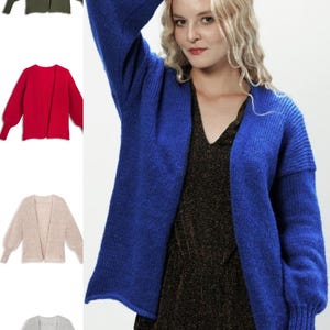 Może przedstawiać: Kobieta prezentuje żywy niebieski kardigan o luźnym kroju i długich rękawach. Na zdjęciu znajdują się również przykłady podobnych kardiganów w kolorze oliwkowym, czerwonym, beżowym i szarym. Otwarty krój i miękka faktura sugerują wygodny, stylowy element garderoby.