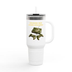 Könnte beinhalten: Weißer Reisebecher mit Henkel und Strohhalm. Der Becher zeigt eine Grafik einer Vintage-Spielkonsole und zwei Controllern mit dem deutschen Text "DRINNEN WAR UNSER DRAUSSEN" in Gelb.