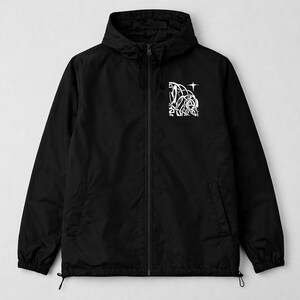 May include: Black hooded jacket with a white graphic design on the chest. The jacket has a zipper closure, two front pockets, and drawstrings at the hem. The graphic is an abstract design with a star.