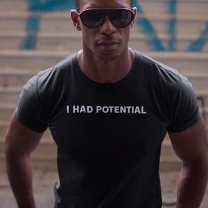 Camiseta "Tenía Potencial", Camiseta Divertida y Sarcástica, Camiseta Gráfica de Humor Negro, Estilo Minimalista, Ropa Urbana de Dr Grace, Camiseta "Ave María" con Manos de Jazz