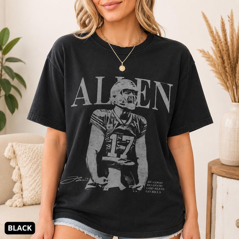 May include: A black short-sleeve t-shirt featuring a graphic of a football player wearing a jersey with the number 17. The text ALLEN is printed in large letters above the player, and the text BE GOOD DO GOOD GOD BLESS GO BILLS is below.