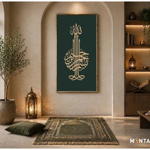 Op de afbeelding: Een interieur met een ingelijst kunstwerk met gouden Arabische kalligrafie op een donkergroene achtergrond. De kamer omvat een gebedskleed, een decoratieve lantaarn en een olijfboom in pot, wat een spirituele sfeer creëert.