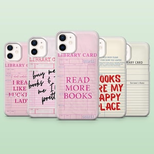 May include: Five phone cases featuring library card designs in pink and white. The cases display phrases such as "Read More Books" and "Books Are My Happy Place" in black and red. Each case has a unique design, evoking a vintage aesthetic.