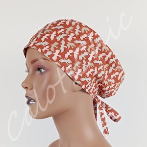 Berretto da donna con stampa a blocchi e motivo di uccelli in terracotta in volo.