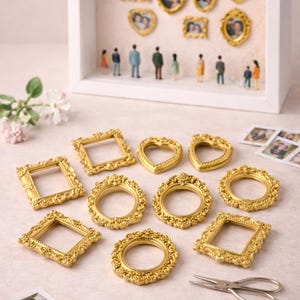 May include: Miniature gold picture frames in square, circular, and heart shapes. A white shadow box contains framed photos and tiny figurines. The ornate frames are ideal for displaying small photos. The frames are approximately 5 cm in diameter.