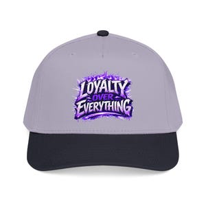 Puede incluir: Gorra de béisbol con corona gris claro y visera azul marino oscuro. La gorra presenta el texto "LOYALTY OVER EVERYTHING" en una fuente púrpura estilizada con un diseño en forma de llama.