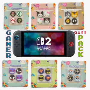 May include: A black Nintendo Switch console with a screen displaying the Nintendo Switch 2 logo, surrounded by six retail packages of colourful silicone thumb grips featuring various character designs including Mario, Hello Kitty, and superheroes.