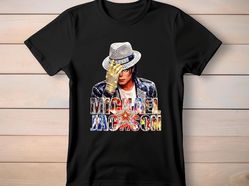 May include: Black t-shirt featuring a graphic of Michael Jackson wearing a fedora and gold glove. The shirt has the text "MICHAEL JACKSON" in a colorful, stylized font with a star in the center.