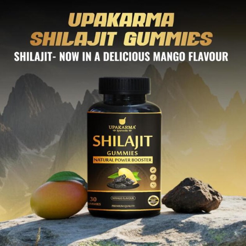 K&ouml;nnte beinhalten: Eine schwarze Flasche Shilajit Gummies mit dem Text "UPAKARMA SHILAJIT GUMMIES" und "SHILAJIT - NOW IN A DELICIOUS MANGO FLAVOUR". Eine Mango und ein dunkler Felsen befinden sich neben der Flasche. Das Etikett lautet "Natural Power Booster".