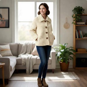Puede incluir: Chaqueta de crochet color crema con cuello grande y cuatro botones marrones. La chaqueta tiene dos bolsillos delanteros y se usa con vaqueros azules y botas marrones. Prenda hecha a mano y acogedora.