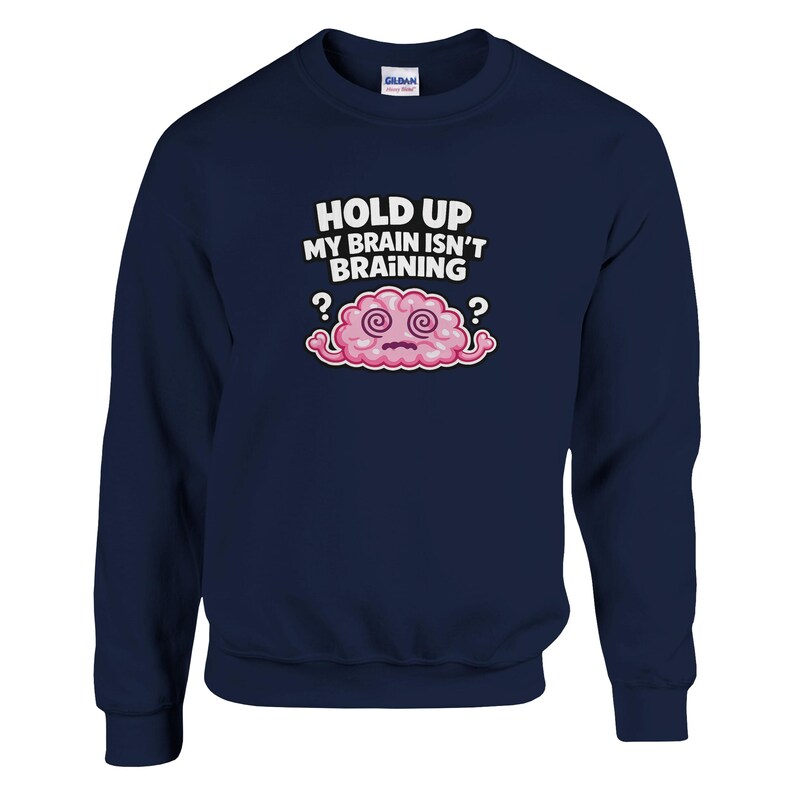 May include: Navy blue sweatshirt featuring the phrase "HOLD UP MY BRAIN ISN'T BRAINING" and a cartoon brain. The brain is pink with a white outline and has dizzy eyes, with question marks on either side.