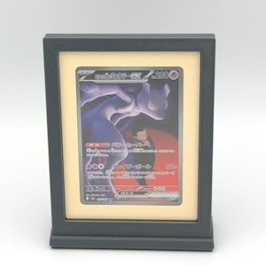 Könnte beinhalten: Ein Set aus drei Keramikbechern mit gesprenkelter, matter Oberfläche. Die Becher sind in den Farbtönen Creme, Hellgrau und Dunkelgrau gehalten. Jeder Becher hat ein schlichtes, minimalistisches Design und einen abgerundeten Henkel. Die Becher sind gestapelt.