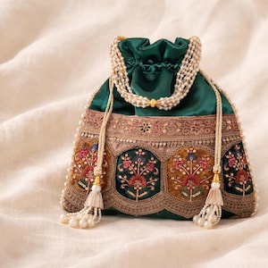 May include: A dark green drawstring bag with intricate embroidery and pearl accents. The bag features floral patterns in shades of pink, orange, and blue, with gold and brown trim. A pearl strand and tassels add to the elegant design.