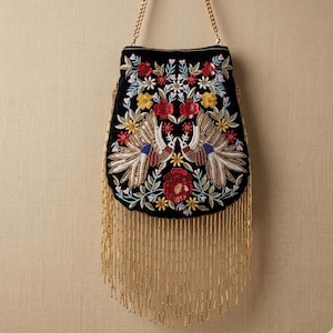 May include: Black beaded handbag with a gold chain strap and gold fringe. The bag features an embroidered floral design with red, yellow, and blue accents. The design includes two birds facing each other.