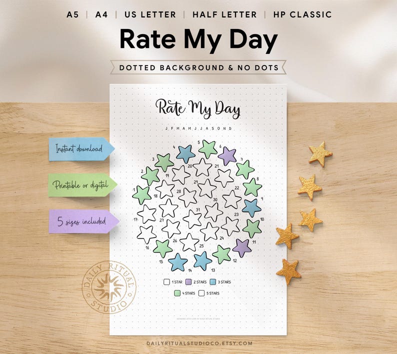 Rate My Day printable displayed on a wooden desk. The page features a circular star-shaped monthly tracker with numbered days, where stars are coloured to rate each day from 1 to 5 stars. A legend shows 1 star through 5 stars. Text indicates instant download, printable or digital use, dotted or plain background options, and five sizes included: A5, A4, US Letter, Half Letter, and Happy Planner Classic.
