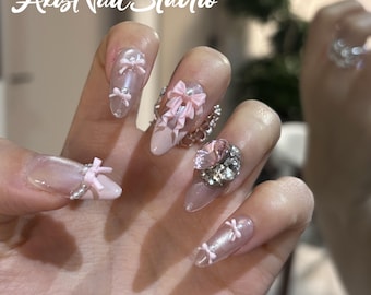 Unghie finte con fiocco rosa e anello di strass, stile principessa.
