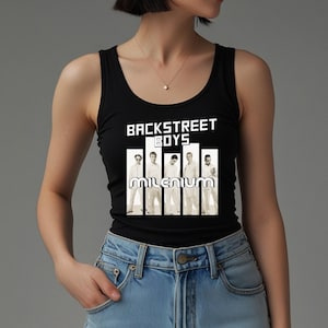 May include: Black tank top featuring the text "BACKSTREET BOYS" above a graphic of the band members and the word "MILENIUM". The top is worn by a person in blue jeans.