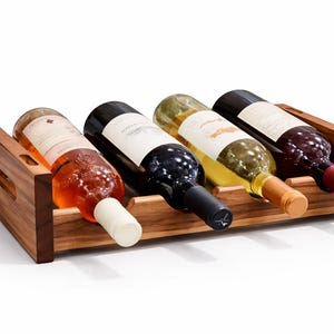 May include: A wooden wine rack holding four bottles of wine. The bottles are filled with red, white, and rosé wine. The rack is made of dark wood and has a simple, rectangular design. The bottles are arranged horizontally.