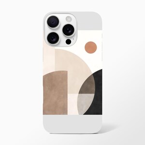 May include: A white phone case featuring an abstract geometric design. The design incorporates shapes like circles, semi-circles, and rectangles in shades of brown, beige, and black, with a small orange circle. The case has a smooth finish.