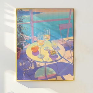 Puede incluir: Una impresión artística enmarcada representa una escena exterior serena. Dos copas de vino, un pequeño cuenco de aceitunas y una naranja descansan sobre una mesa redonda. El fondo muestra una vista costera con una silla y una ventana.