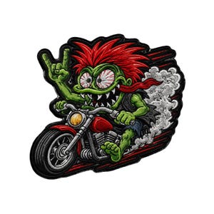 May include: An embroidered patch featuring a green monster with spiky red hair riding a red motorcycle. The creature has wide, bloodshot eyes, sharp teeth, and is making a rock-and-roll hand gesture. Gray smoke trails behind the bike.